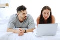 Ã Â¹ÂÃ Â¹ÂYoung Caucasian couple relaxing with laptop in social media for shopping online in bedroom. Technology for Married family Royalty Free Stock Photo
